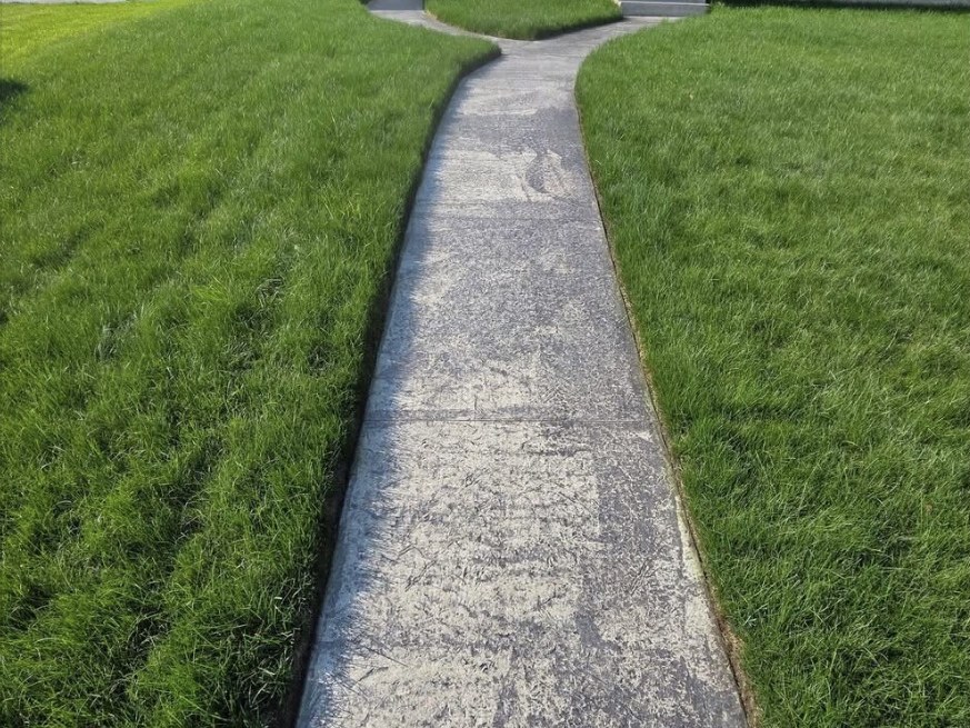 Faded grey stamped concrete front walkway before sealing