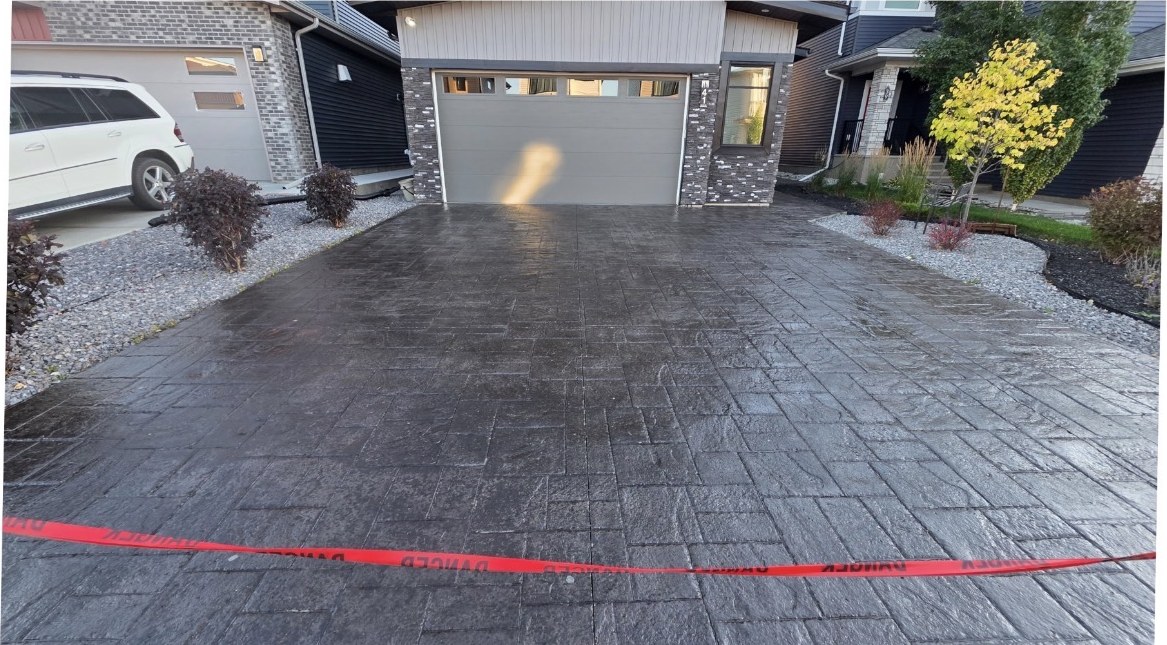 The same stamped driveway after cleaning and sealing, with deep restored colour and a wet look