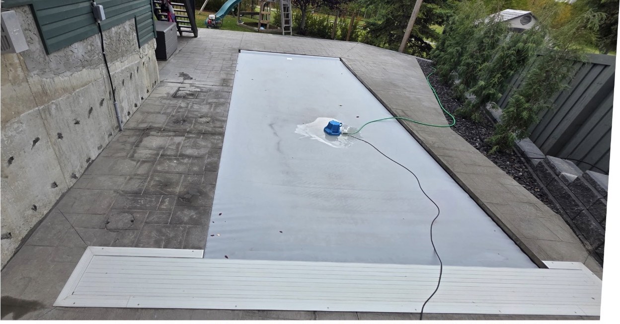 Faded stamped concrete patio around a covered pool before sealing
